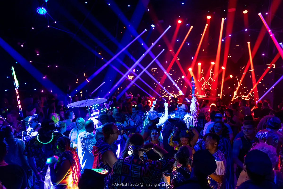 Crowd at Crystal Six event with vibrant red and blue laser lights