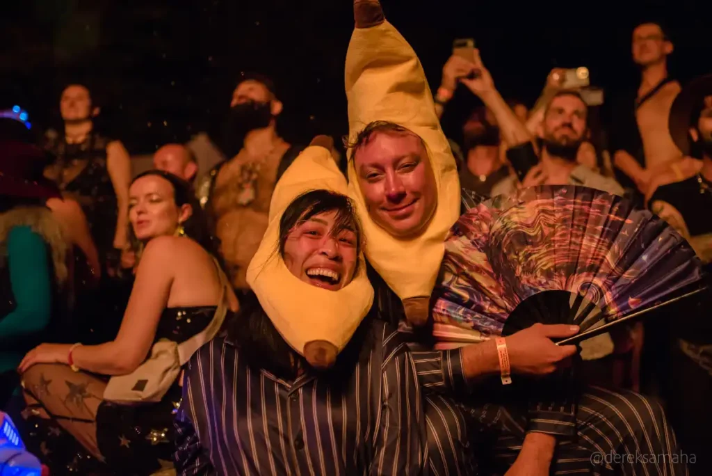 A couple facing the bonfire wearing banana costumes