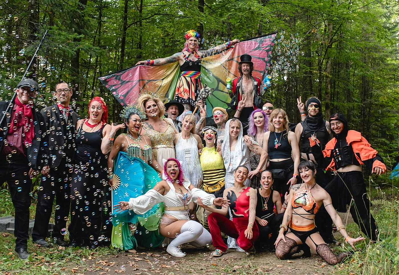 NorthFIRE Harvest Cabaret circus performers in a forest clearing.