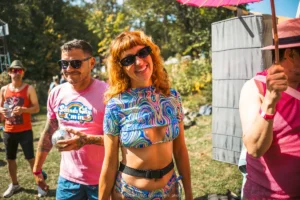 HARVEST 2025, @milabright_photo-3424 Woman in colorful outfit at outdoor festival with pink umbrella