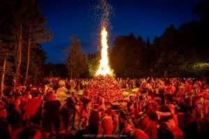 HARVEST 2025, @milabright_photo-3764 Harvest festival attendees gather around a large bonfire at night.