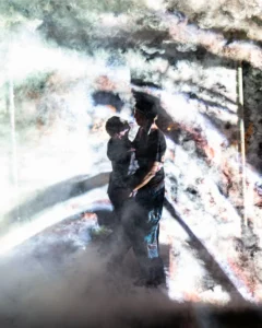 smoke-cube-couple-tallandvibin Silhouettes of two dancers embracing amidst swirling smoke and dramatic lighting.